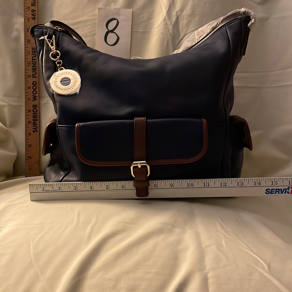 Brand new never used Black leather Isaac Mizrahi purse. Brown leather trim/strap